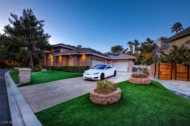 view of front of property with a front yard, fence, solar panels, concrete driveway, and brick siding