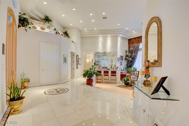 interior space with light tile patterned floors and a high ceiling