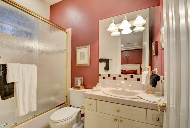 full bathroom with backsplash, shower / bath combination with glass door, vanity, and toilet