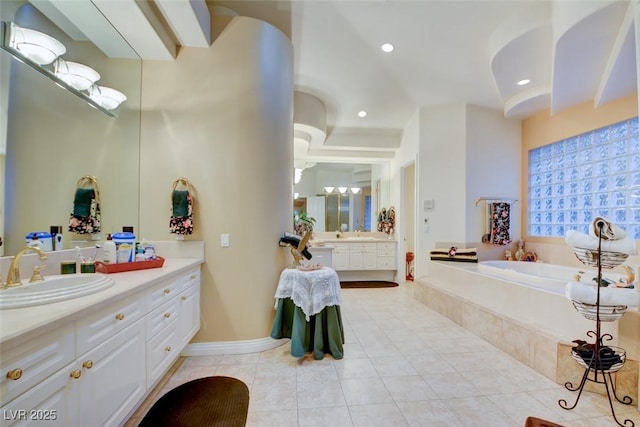 bathroom with tile patterned floors, a tub, and vanity