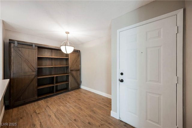 unfurnished dining area with hardwood / wood-style floors and a barn door