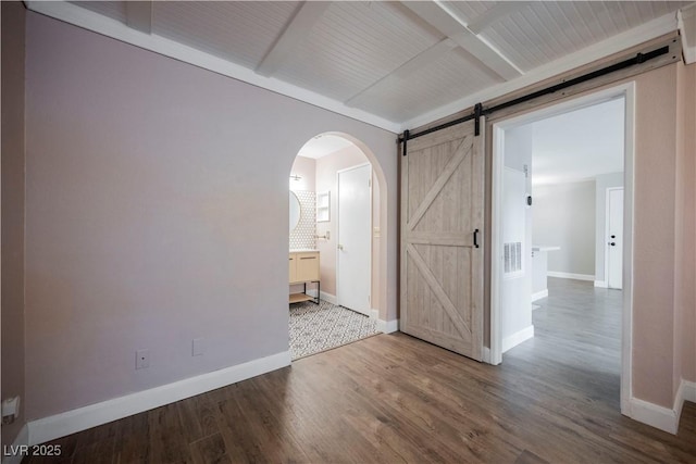 spare room featuring hardwood / wood-style flooring and a barn door