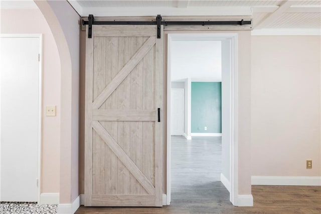 corridor with a barn door and hardwood / wood-style flooring