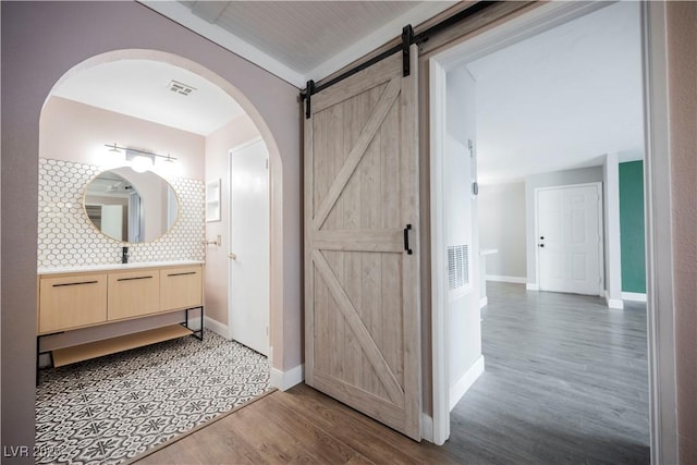 bathroom with vanity, wood-type flooring, and backsplash