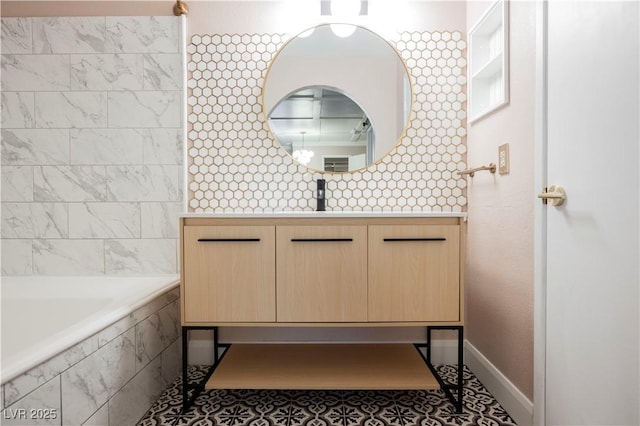 bathroom with tile patterned flooring, vanity, and a relaxing tiled tub