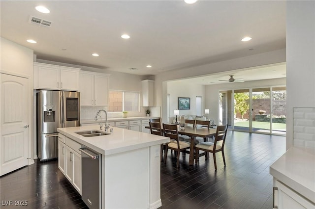 kitchen featuring white cabinets, appliances with stainless steel finishes, an island with sink, and sink