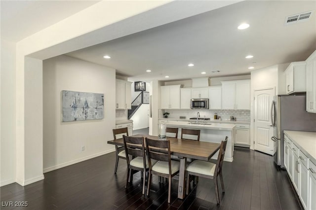 dining space with dark hardwood / wood-style floors and sink