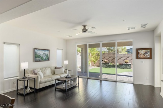 living room with a wealth of natural light, ceiling fan, and dark hardwood / wood-style floors