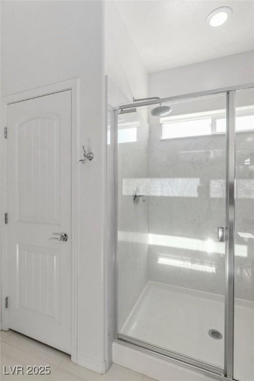 bathroom featuring tile patterned flooring and an enclosed shower