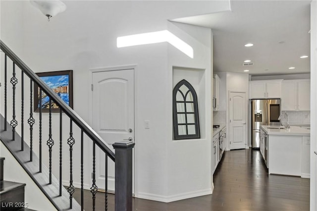 stairway with hardwood / wood-style floors and sink