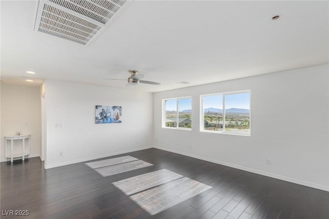 spare room featuring ceiling fan, dark hardwood / wood-style floors, and a mountain view