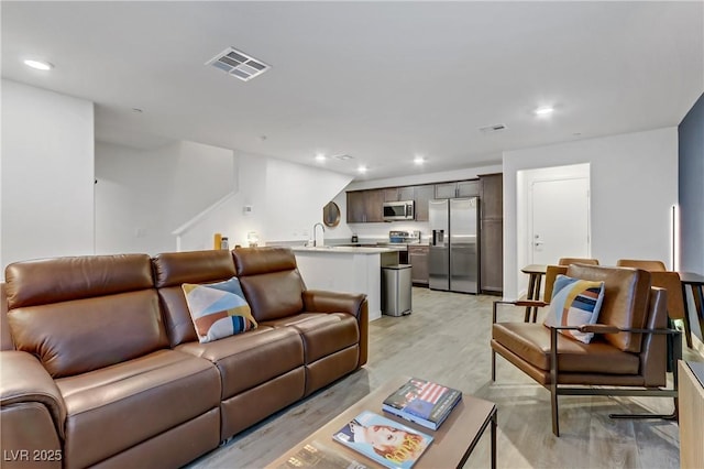 living room featuring light hardwood / wood-style flooring and sink