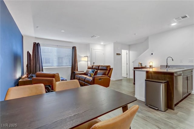 dining space with light wood-type flooring and sink