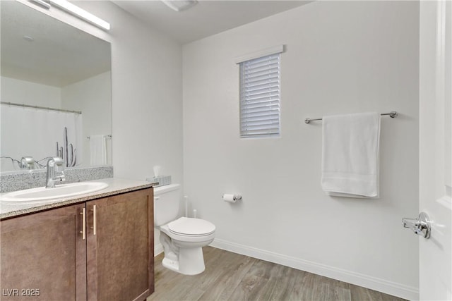 bathroom featuring toilet, vanity, and hardwood / wood-style flooring