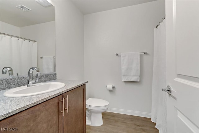 bathroom featuring toilet, vanity, and hardwood / wood-style flooring