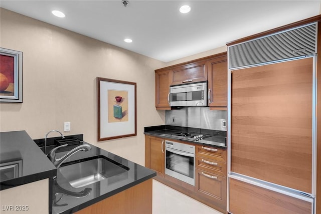 kitchen with appliances with stainless steel finishes, backsplash, and sink