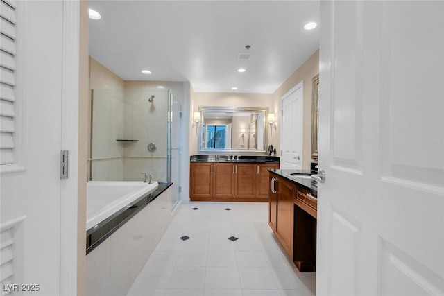 bathroom featuring plus walk in shower, vanity, and tile patterned floors