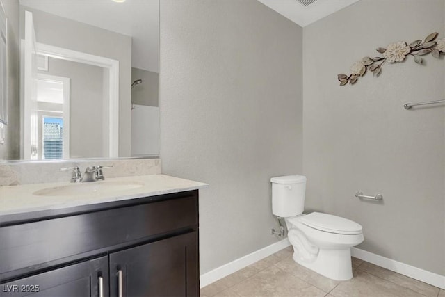 bathroom featuring baseboards, vanity, toilet, and tile patterned floors