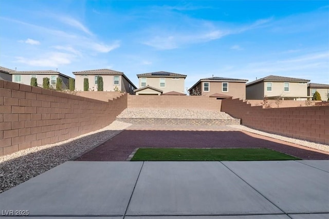 view of yard with a patio, a fenced backyard, and a residential view