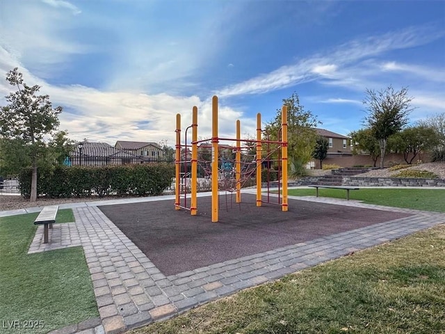 community play area with fence and a lawn