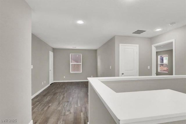 hallway with recessed lighting, visible vents, baseboards, and wood finished floors