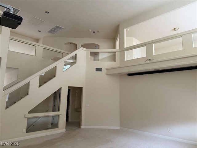 unfurnished living room with a towering ceiling