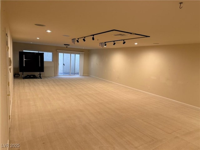 spare room featuring light colored carpet and track lighting