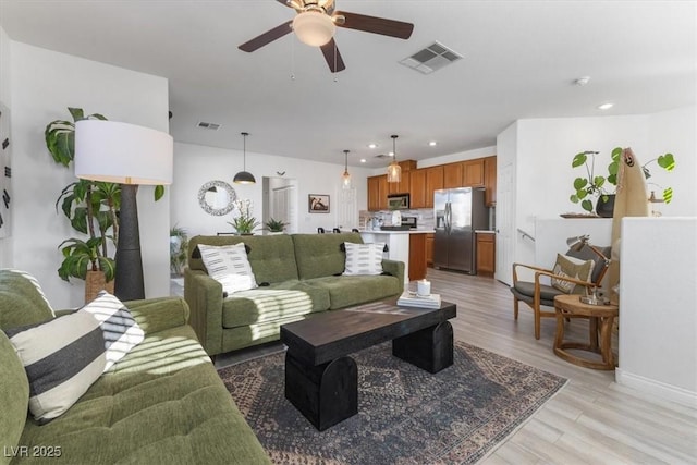 living room featuring ceiling fan and light wood-type flooring