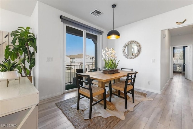 dining room with a healthy amount of sunlight and light hardwood / wood-style floors