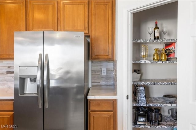 kitchen with stainless steel fridge and tasteful backsplash