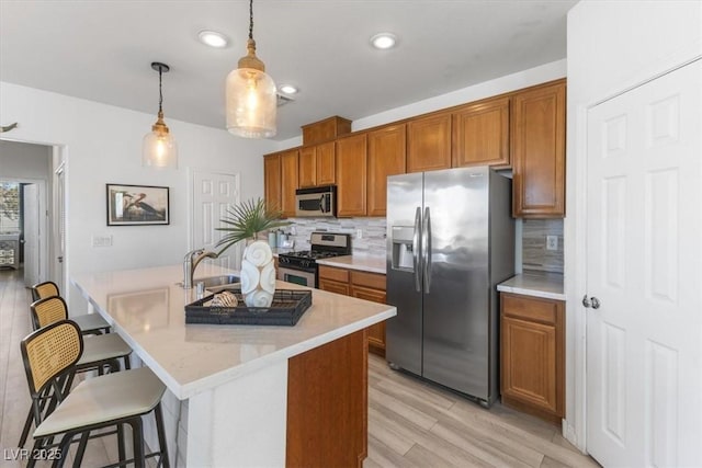 kitchen with stainless steel appliances, pendant lighting, a kitchen bar, and backsplash