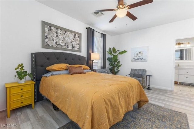 bedroom featuring ceiling fan, ensuite bathroom, and hardwood / wood-style flooring