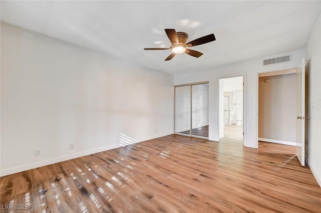 unfurnished bedroom featuring ceiling fan, a closet, and light hardwood / wood-style flooring