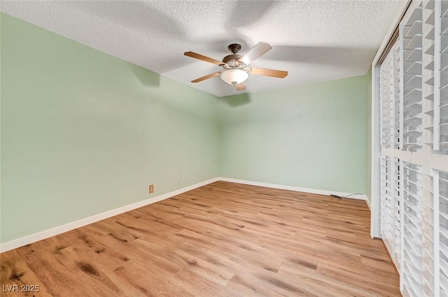 empty room with ceiling fan, a textured ceiling, and light hardwood / wood-style flooring