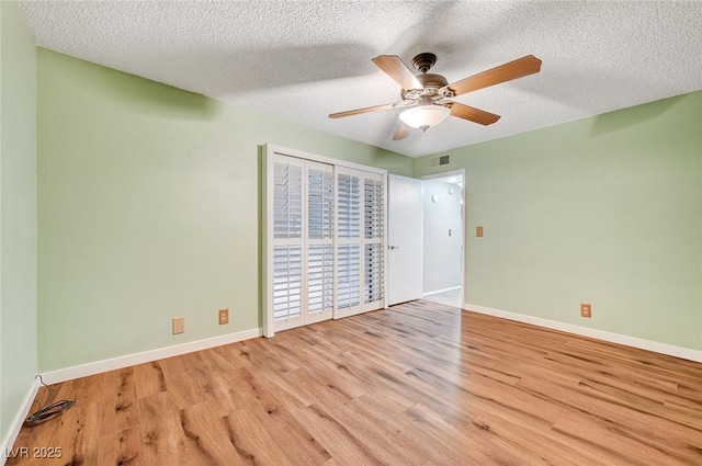 unfurnished bedroom featuring ceiling fan, light hardwood / wood-style floors, and a textured ceiling