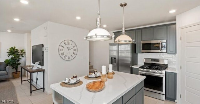 kitchen with a center island, stainless steel appliances, pendant lighting, gray cabinets, and light tile patterned flooring