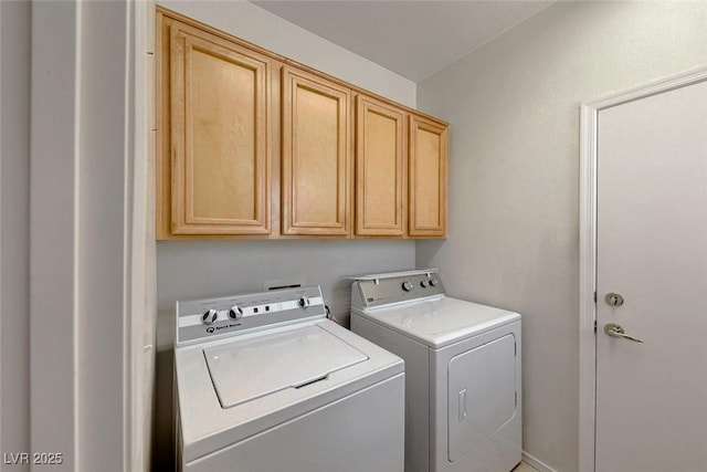 laundry area with washing machine and dryer and cabinets