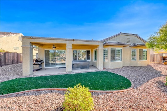 back of house with a hot tub, ceiling fan, and a patio area