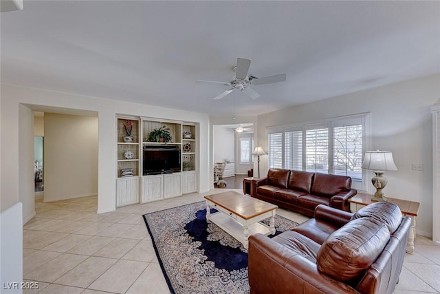 tiled living room with built in features and ceiling fan