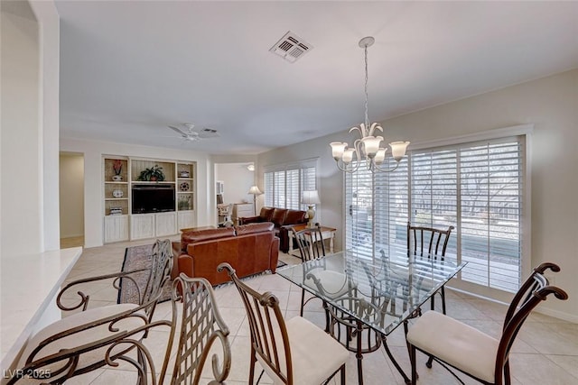 dining space featuring plenty of natural light, ceiling fan with notable chandelier, light tile patterned floors, and built in shelves