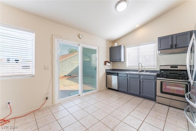 kitchen with a healthy amount of sunlight, sink, appliances with stainless steel finishes, and vaulted ceiling