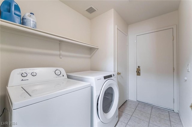 laundry area with washer and dryer and light tile patterned floors