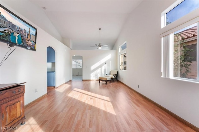 living room featuring ceiling fan, lofted ceiling, a wealth of natural light, and light hardwood / wood-style flooring