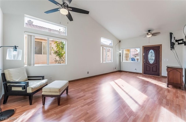 living area featuring ceiling fan, high vaulted ceiling, and light wood-type flooring