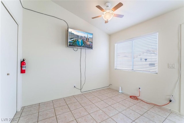 spare room featuring light tile patterned floors, vaulted ceiling, and ceiling fan