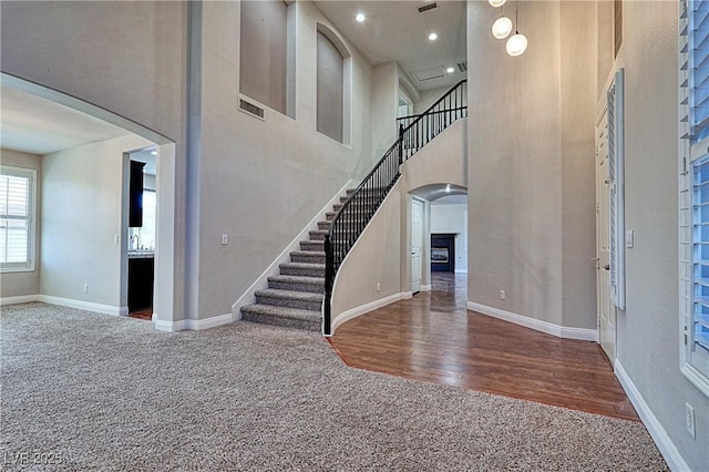 carpeted foyer featuring a high ceiling