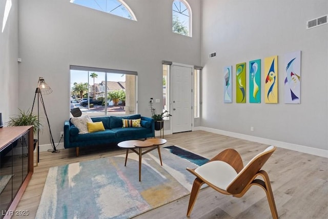 living room featuring light hardwood / wood-style floors and a high ceiling