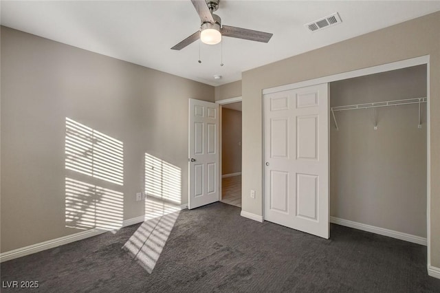 unfurnished bedroom featuring ceiling fan, dark carpet, and a closet