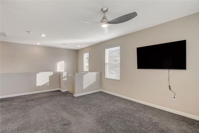 empty room featuring ceiling fan and dark colored carpet