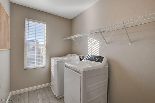 laundry room with washer and dryer and light wood-type flooring